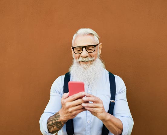 Älterer Mann hält Handy in der Hand
